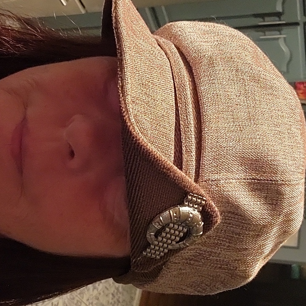 Very cool like new hat/cap. Shiny fabric with faux broch
